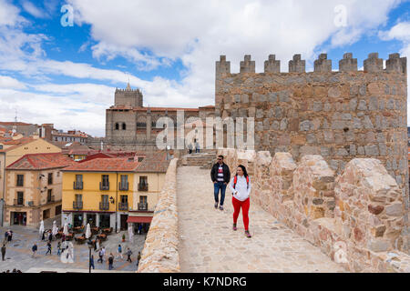 I turisti passeggiano lungo la parte superiore delle mura medievali della città di Avila, Spagna Foto Stock