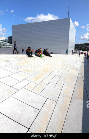 Persone rilassante sotto il sole sul tetto del Teatro dell'Opera di Oslo, Norvegia Foto Stock