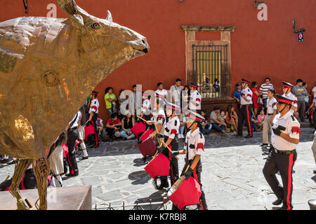 Una scuola militare parate di banda attraverso il quartiere storico passato di una scultura di un toro durante il giorno dell indipendenza messicana celebrazioni settembre 16, 2017 in San Miguel De Allende, Messico. Foto Stock