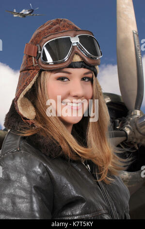 La donna che indossa pilota pilota vintage casco giacca di volo e gli occhiali di protezione Foto Stock