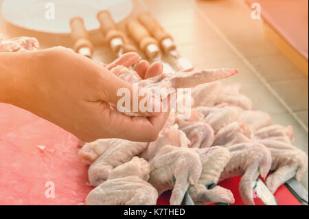 Canto mette i pezzi di pollo marinato alla griglia in cucina in una giornata di sole. Close-up. Il telaio orizzontale. Foto Stock