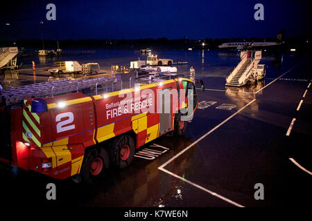 Belfast International Airport di soccorso ed antincendio in attesa del veicolo sul cavalletto di notte sotto la pioggia Foto Stock