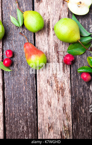 Pera e piccolo apple su legno sfondo rustico. vista dall'alto. telaio. raccolto autunnale. spazio copia Foto Stock