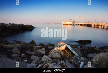 Lunga esposizione della costa e casa in legno sul mare di Durazzo, Albania al mattino all'alba Foto Stock
