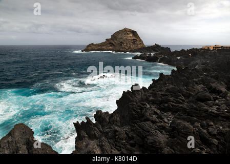 Onde dell'oceano atlantico hit rocce sulla costa dell'isola di Madeira Foto Stock