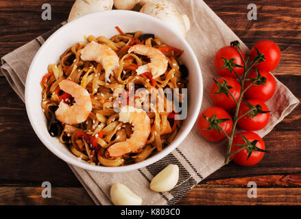 Stir-fritte tagliatelle cinesi con gamberi e verdure su nero Foto Stock
