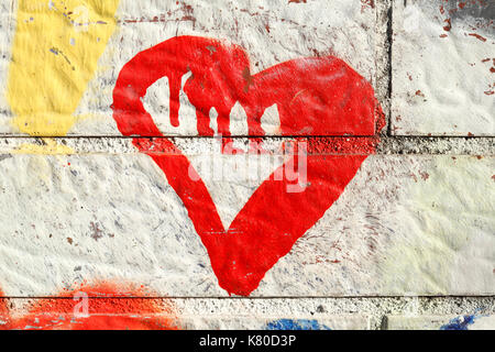 Cuore rosso dipinto su un bianco muro di mattoni Foto Stock