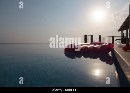 Bugia bassa e anelli flottanti in piscina Foto Stock