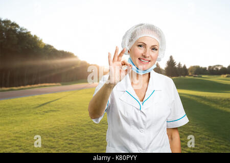 Medico donna che mostra segno ok. Foto Stock