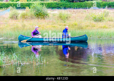 Loch Ard, Scotland, Regno Unito. Il 17 settembre 2017. Regno Unito Meteo: due persone sguazzare un open di canoa, la calma giorno fornisce riflessioni sulla superficie dell'acqua. Loch Ard è un corpo di acqua dolce nel Loch Lomond e il Trossachs Parco Nazionale del Distretto di Stirling in Scozia. Credito: Berretto Alamy/Live News Foto Stock