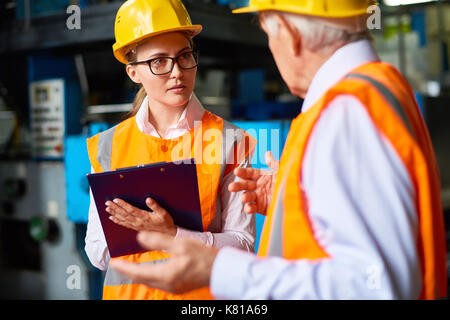 Discussione produttiva dei lavoratori in fabbrica Foto Stock