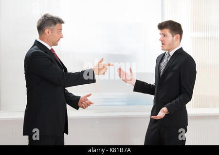 Due imprenditori quarreling con ogni altro in ufficio Foto Stock