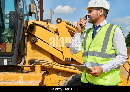 Occupato lavoratore edile in tuta Foto Stock