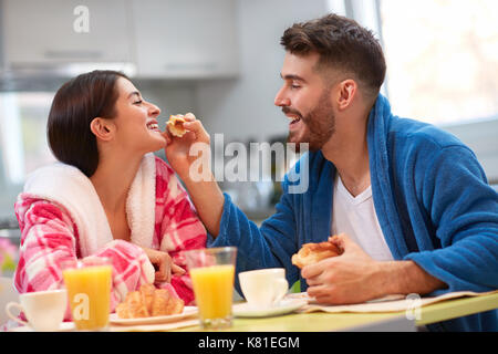 Coppia giovane divertendosi in cucina durante la prima colazione Foto Stock