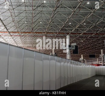 Capannone / hangar interni con travi in acciaio e di sostegno e luce a soffitto, parete a secco il percorso e le unità aria condizionata in background Foto Stock