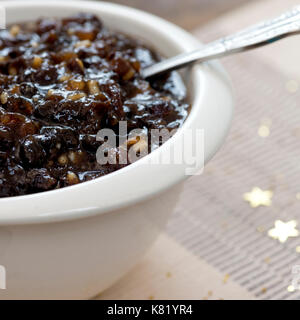 Immagine macro quadrata di mincemeat natalizio tradizionale fatto in casa con frutta mista e brandy in una ciotola bianca, mettere a fuoco sul soggetto, sfondo de Foto Stock