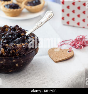 Immagine quadrata del mincemeat di Natale tradizionale fatto in casa concentrarsi sul tema, con mince pies sfondo de focalizzato su spazio di copia dell'annuncio Foto Stock