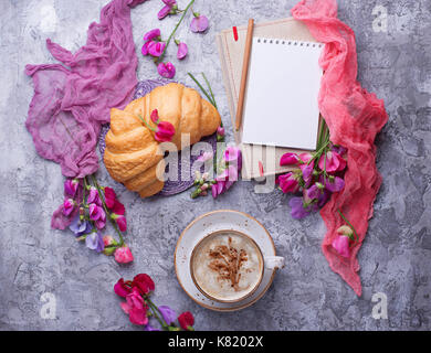 Caffè e Croissant, fiore e notebook. Foto Stock