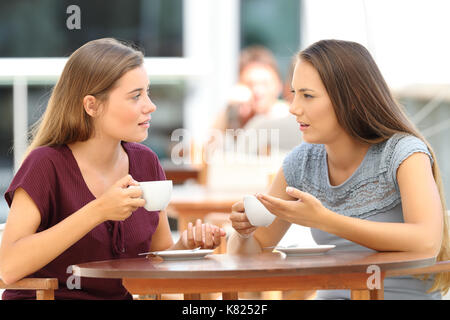 Due gravi amici parlano seduti in un ristorante Foto Stock