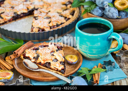 In casa tradizionale torta di prugne con cinamon e mandorle con caffè sul vecchio sfondo di legno Foto Stock