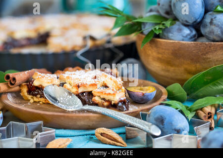 In casa tradizionale torta di prugne con cinamon e mandorle con caffè sul vecchio sfondo di legno Foto Stock