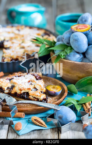 In casa tradizionale torta di prugne con cinamon e mandorle con caffè sul vecchio sfondo di legno Foto Stock