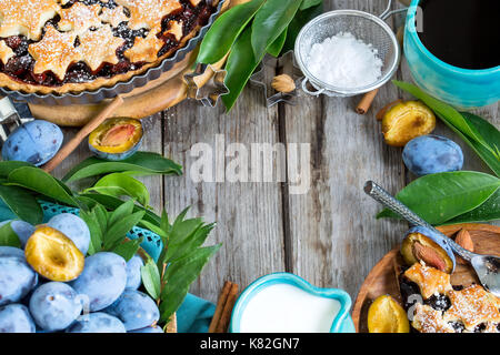 In casa tradizionale torta di prugne con cinamon e mandorle con caffè sul vecchio sfondo di legno Foto Stock