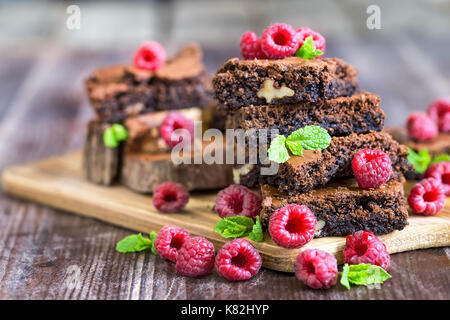 Brownie piazze decorate con lamponi freschi e foglie di menta Foto Stock