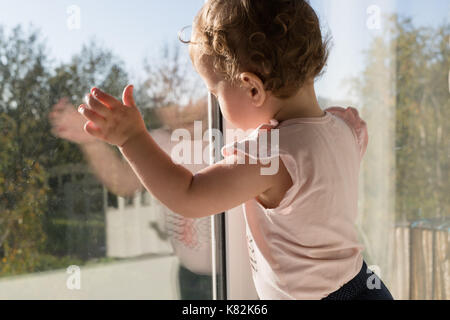 Bambino mediante la finestra Foto Stock