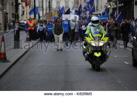 Un poliziotto su una moto conduce un anti-Brexit pro-UE rally attraverso le strade di Londra verso Westminster. Foto Stock