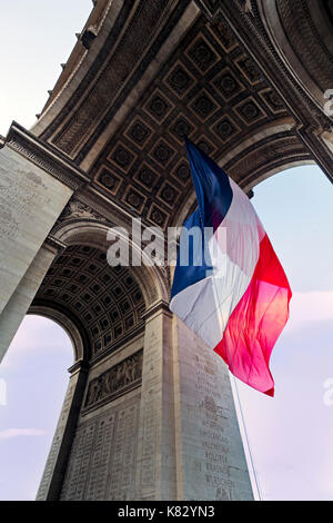 Francia, Parigi, Etoile, bandiera francese sotto Arc de Triomphe costruito da Napoleone Foto Stock