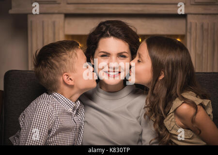 Bambini baciare sorridente madre Foto Stock