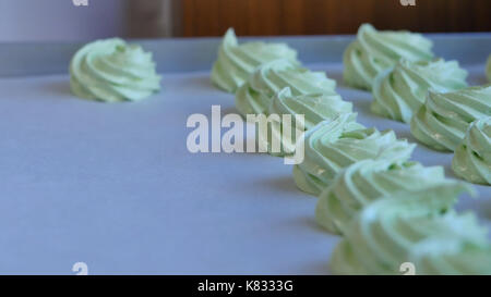 Spremere il ripieno di panna sul cupcake verde, primo piano Foto Stock