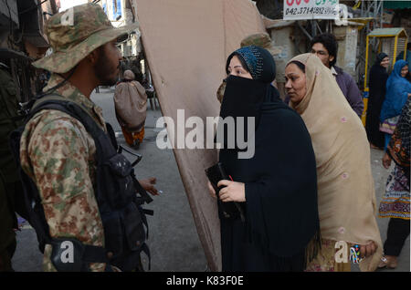 Lahore, Pakistan. Xviii Sep, 2017. Il personale di sicurezza guardia come coda di elettori a votare in na- 120 da-elezione. elezione iniziato alle 8 del mattino in tutto 220 seggi elettorali nella capitale provinciale. un totale di 44 candidati stanno contestando per l assemblea nazionale sede di Lahore. Credito: rana sajid hussain/Pacific press/alamy live news Foto Stock