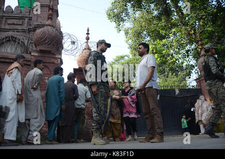 Lahore, Pakistan. Xviii Sep, 2017. Il personale di sicurezza guardia come coda di elettori a votare in na- 120 da-elezione. elezione iniziato alle 8 del mattino in tutto 220 seggi elettorali nella capitale provinciale. un totale di 44 candidati stanno contestando per l assemblea nazionale sede di Lahore. Credito: rana sajid hussain/Pacific press/alamy live news Foto Stock