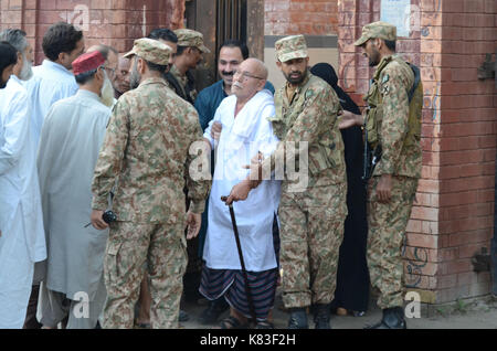 Lahore, Pakistan. Xviii Sep, 2017. Il personale di sicurezza guardia come coda di elettori a votare in na- 120 da-elezione. elezione iniziato alle 8 del mattino in tutto 220 seggi elettorali nella capitale provinciale. un totale di 44 candidati stanno contestando per l assemblea nazionale sede di Lahore. Credito: rana sajid hussain/Pacific press/alamy live news Foto Stock