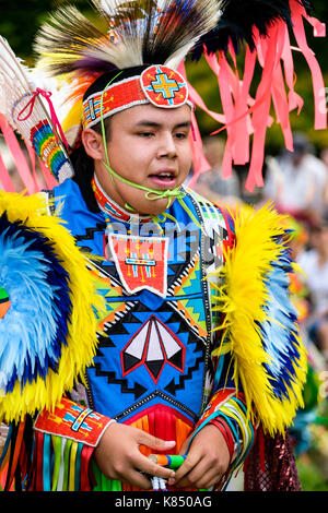Le Prime Nazioni adolescente ragazzo ballerino fantasia vestito con colorati regalia per eseguire l'erba ballare durante un Pow Wow a Londra, Ontario, Canada. Foto Stock