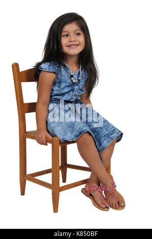 Bello e giovane elegante bambina seduto in una sedia Foto Stock