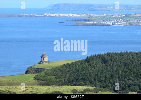 In discesa, la Causeway coast, Irlanda del Nord, Regno Unito. Xvii Sep, 2017. Una bella giornata di sole e un cielo terso tornare alla famosa in tutto il mondo costa causeway e creare un atmosfera mediterranea dopo un periodo di brutto tempo. L'iconica Mussenden Temple appollaiato sul ciglio della scogliera si affaccia sulla città di mare di portstewart a destra e portrush a sinistra, entrambi confezionati con i turisti e la gente del luogo che realizza la maggior parte del tempo buono credito: eoin mcconnell/alamy live news Foto Stock