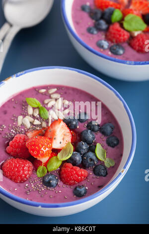 Una sana berry smoothie ciotola con Fragole Lamponi Mirtilli e semi di Chia Foto Stock