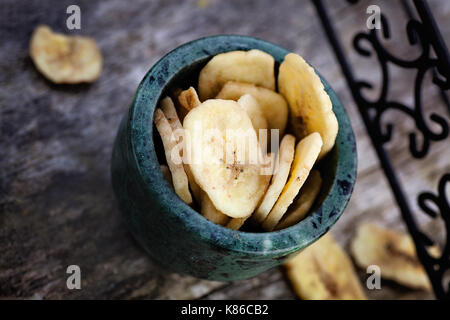 Mangiare sano. Banane essiccate frutta su sfondo di legno Foto Stock