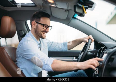Uomo che utilizza il sistema di navigazione GPS in auto per viaggiare Foto Stock