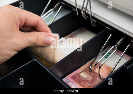 Close-up di persona mani tenendo la banconota in cassa Foto Stock