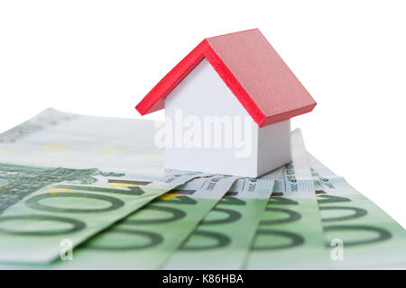 Primo piano della casa sul modello di banconote isolate su sfondo bianco Foto Stock