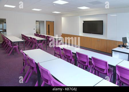Una moderna aula in una nuova Londra scuola secondaria. Mostra layout tradizionale con banchi di fronte a un grande monitor per computer. Foto Stock