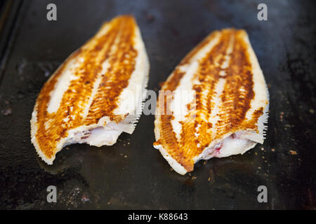 Angolo alto close up di due filetti grigliate di pesce. Foto Stock