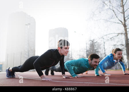 Gruppo sportivo sano determinati amici fitness training toge Foto Stock