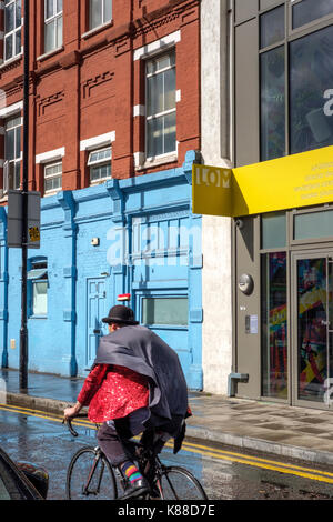 Sclater street,e1,shoreditch,Londra,-ciclista in glittery red jacketand top hat Foto Stock