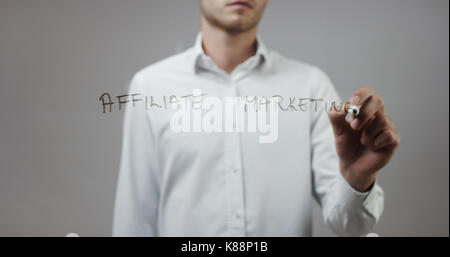 Il marketing di affiliazione, uomo scrittura su vetro Foto Stock