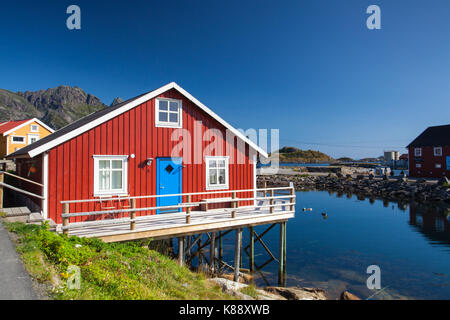 Henningsvaer, Norvegia - agosto 19,2017: il pittoresco porto di pesca in henningsvaer sulle isole Lofoten in Norvegia con rosso tipico degli edifici in legno e piccolo Foto Stock